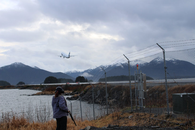 Between Delta and Alaska Airlines, over half a dozen flights come into and out of Sitka daily. After clearing the runway of some ducks, Bauscher looks on as a plane takes off. (Photo by Emily Kwong/KCAW photo)