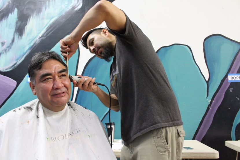 John Ross gets his hair cut by one of the barbers at Shear Attraction. (Photo by Elizabeth Jenkins/KTOO) 