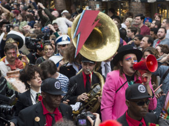 Win Butler (with red megaphone) and Regine Chassagne (lower left, with keytar) of Arcade Fire lead a parade through New Orleans' French Quarter with members of the Preservation Hall Jazz Band in honor of David Bowie. Erika Goldring for NPR