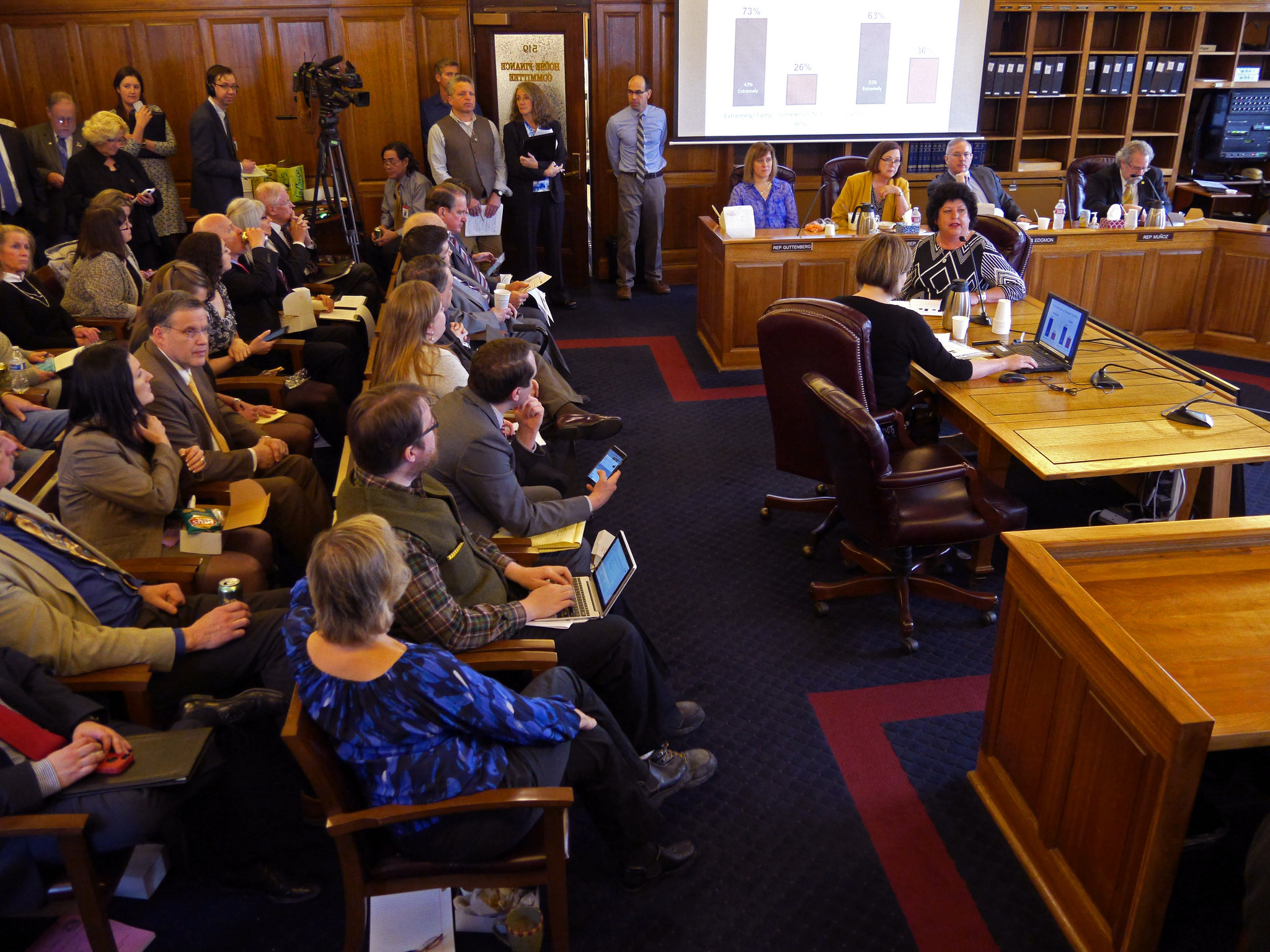 Diane Kaplan, president and CEO, Rasmuson Foundation (at table facing camera) presents the results of a public survey to the House Finance Committee, January 20, 2016. The Rasmuson survey asked Alaskans what they think about the state’s fiscal crisis. (Photo by Skip Gray/360 North.)