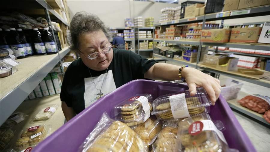 A volunteer unloads donated baked goods at a food bank in Des Moines, Iowa. Food banks could become strained, as more than 500,000 people could lose food stamps in 22 states reinstating work requirements this winter. AP