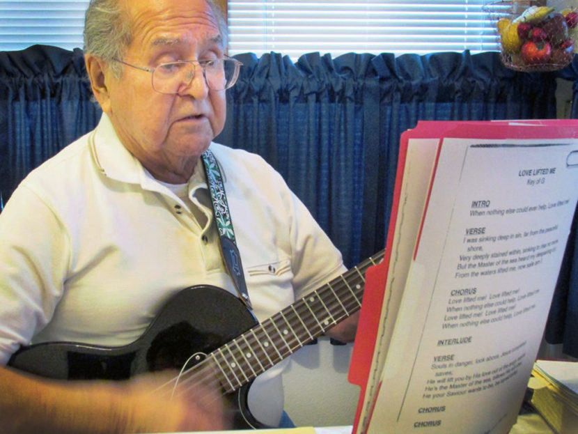 Ketchikan’s Fred John sings and plays a gospel song in his kitchen. He’s volunteered at Ketchikan’s prison and other locations. (Photo by Leila Kheiry/KRBD)