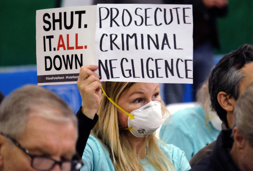 On Jan. 16, Tera Lecuona, resident of the Porter Ranch area of Los Angeles, holds a protest sign during a hearing over a gas leak at Southern California Gas Co.'s Aliso Canyon Storage Facility. The company faces misdemeanor charges as well as numerous civil lawsuits. (Richard Vogel/AP)