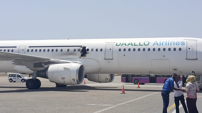 A hole is seen in a plane operated by Daallo Airlines as it sits on a runway at the airport in Mogadishu, Somalia, on Tuesday. (AP)