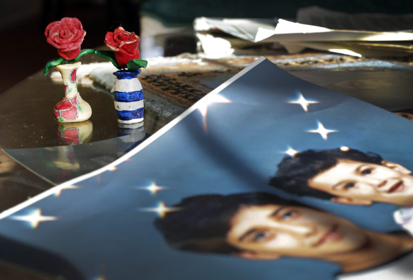 On Dec. 10, 2014, prison artwork created by Adnan Syed sits near family photos in the Baltimore home of his mother, Shamim Syed. Syed, convicted in 2000 of murdering his girlfriend, is appearing at a hearing Wednesday to request a new trial, based on evidence uncovered by the podcast Serial. Patrick Semansky/AP