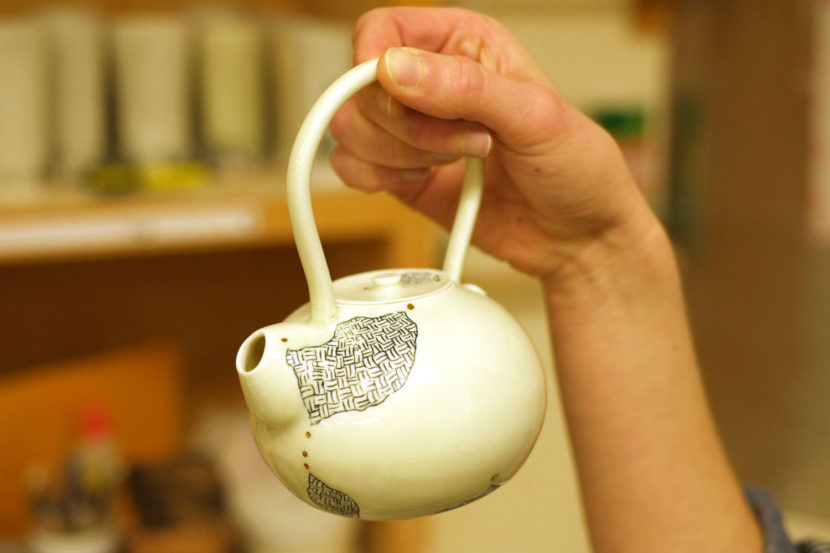 Mercedes Muñoz holds a tea pot that features a cross-hatching design inspired by the work of her grandmother, Rie Muñoz. (Photo by Annie Bartholomew/KTOO)