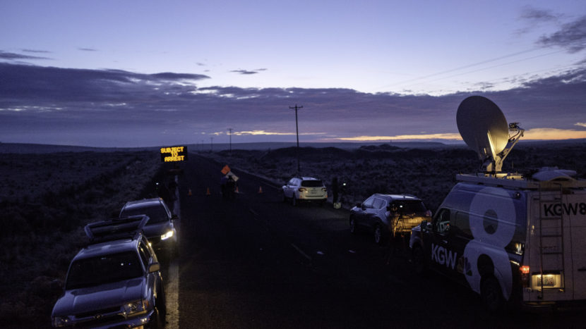 Media wait at a checkpoint about 4 miles from the Malheur Wildlife Refuge Headquarters near Burns, Ore., as the sun rises on Thursday. The FBI had surrounded the last four protesters holed up at a federal wildlife refuge in Oregon and were waiting for them to surrender. (Rob Kerr/AFP/Getty Images)