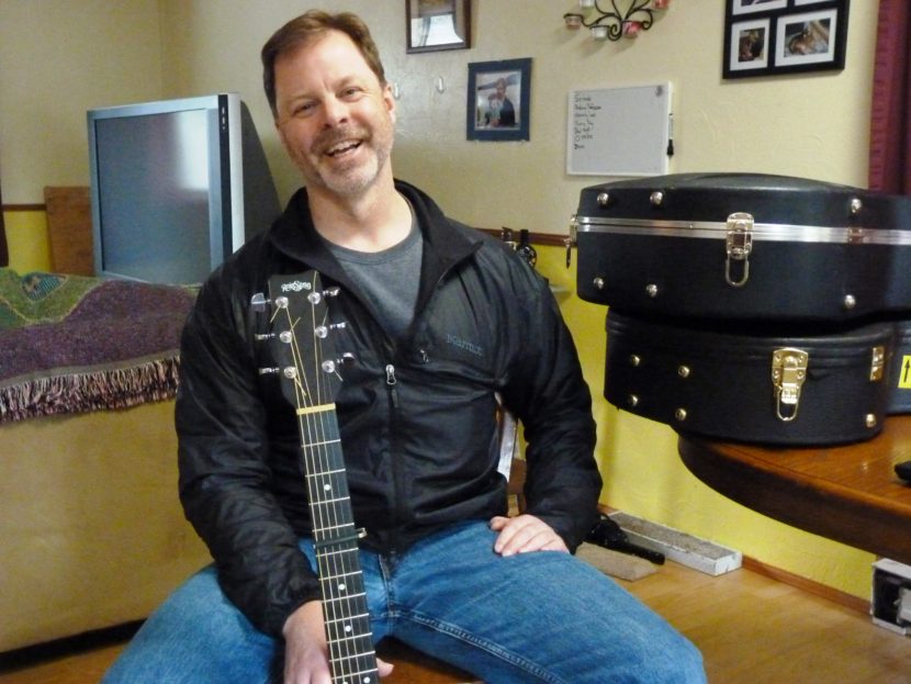 Juneau guitarist, singer and songwriter Kray Van Kirk talks about his music in his dining room. He'll perform during the Alaska Folk Festival, April 4-11 in Juneau. (Photo by Ed Schoenfeld/ CoastAlaska News)
