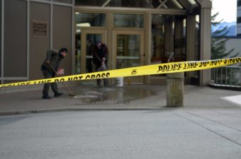 Two men clean the sidewalk outside the Dimond Courthouse Monday. Police say 34-year-old Miranda Ellen Davison intentionally shot herself in the chest. (Photo by Jennifer Canfield/KTOO)