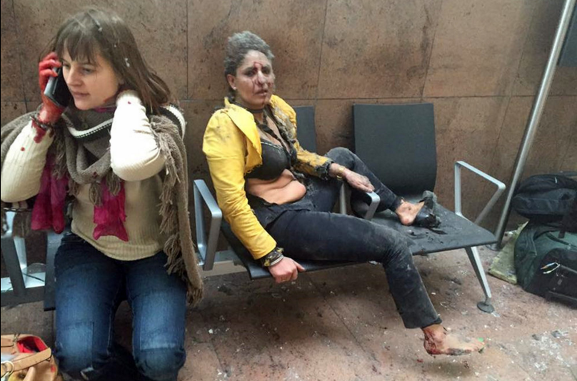 Two women sit in the airport in Brussels after the Tuesday morning explosions. The blasts hit near the departure gates, collapsing ceiling panels and shattering glass windows; Belgian media said 11 people were killed. Ketevan Kardava/AP
