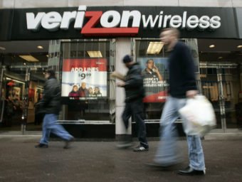 Pedestrians walk past a Verizon Wireless shop. Charles Dharapak /AP