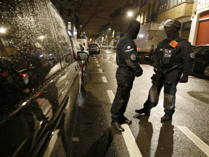 Police stand at a checkpoint during a raid in the suburb of Schaerbeek in Brussels on Thursday.