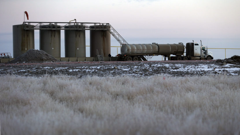 An oil field truck is used to make a transfer at oil-storage tanks in Williston, N.D., in 2014. It was atop tanks like these that oil worker Dustin Bergsing, 21, was found dead. (Eric Gay/AP)