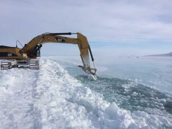 Excavators dig trenches up to 5 feet deep to channel water from the Sagavanirktok River away from the northernmost stretch of the Dalton Highway. (Photo courtesy of Alaska Department of Transportation)