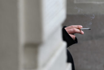 A smoker in San Francisco holds a cigarette. If Gov. Jerry Brown signs the bill, California will become the second state to raise the age limit for buying tobacco products from 18 to 21. Justin Sullivan/Getty Images