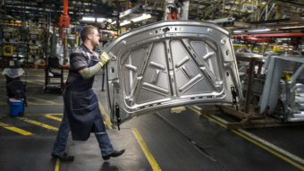 An employee prepares to install the hood on a vehicle at a General Motors plant in Arlington, Texas. Federal Reserve policymakers say recent indicators point to a strengthening labor market. Bloomberg via Getty Images