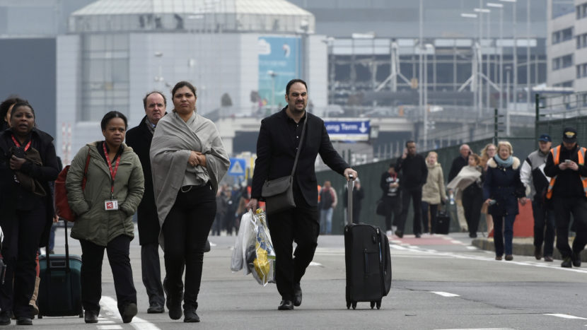 Passengers leave Brussels' Zaventem airport after two explosions killed at least 13 people and injured 35 more. John Thys/AFP/Getty Images
