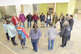 Sharon Isaak (bottom right, grey jacket) leads members of the Kenaitze Indian Tribe's Elders Committee in a closing prayer after the group toured for the first time the tribe's new Elders building on Feb. 11, 2016. (Photo by Scott Moon/Kenaitze Indian Tribe)