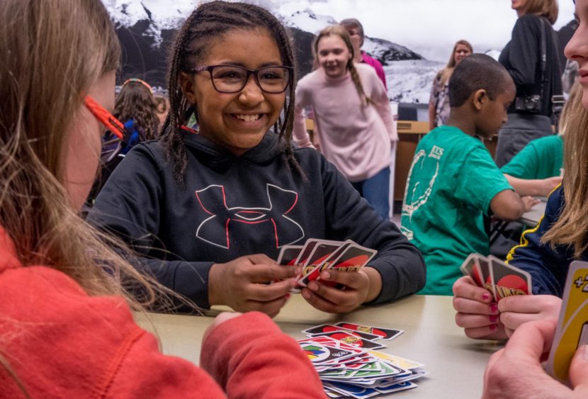 Students play Uno at City Hall with the cards being given out by Mattel as part of their April Fools' day event (Photo by David Purdy/KTOO)