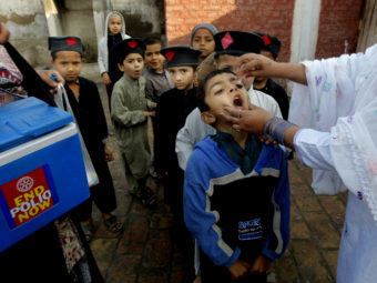A Pakistani health worker gives a polio vaccine to students in Peshawar, Pakistan, in March. Polio remains endemic in Pakistan after the Taliban banned vaccinations, attacks targeted medical staffers and suspicions lingered about the inoculations. Mohammad Sajjad/AP