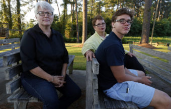 Four couples have won their challenge of Mississippi's ban on same-sex adoption. Two of the plaintiffs, Susan Hrostowski (left) and Kathryn Garner, are seen here last summer with their teenage son, Hudson Garner. Rogelio V. Solis/AP