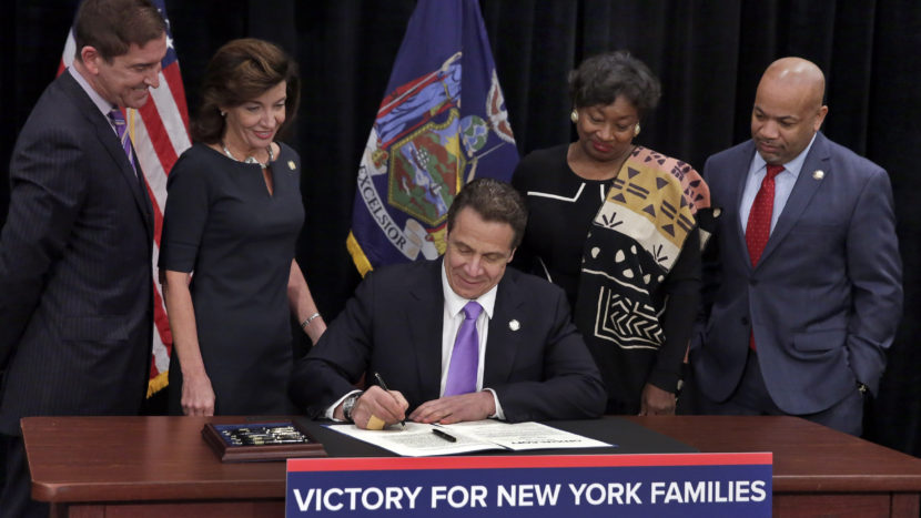 New York Gov. Andrew Cuomo signed a law Monday that will establish a paid-family-leave policy and gradually raise New York's minimum wage, at the Javits Convention Center in New York City. (Richard Drew/Pool/Getty Images)
