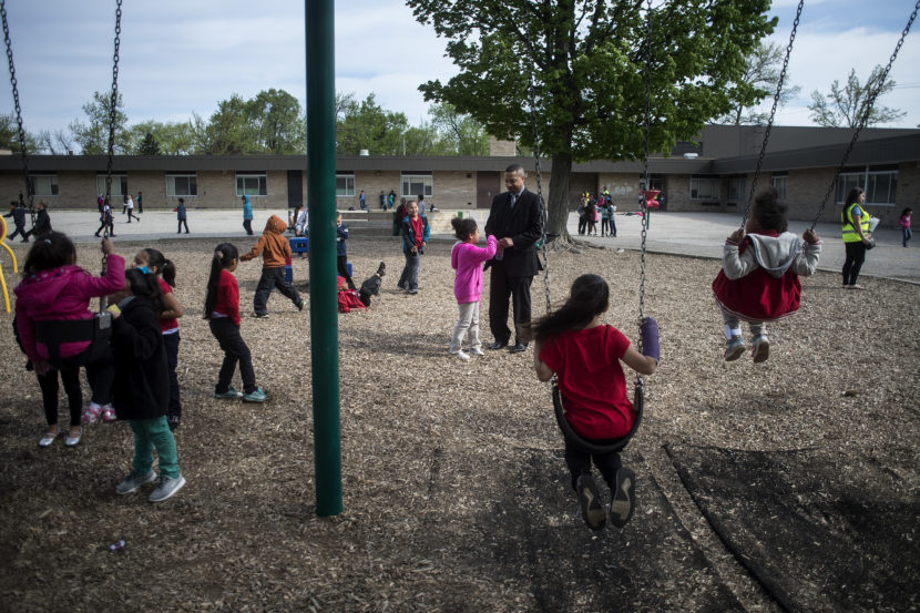 Mel Atkins, center, talks with a Buchanan Elementary School student during recess. (Photo by Brittney Lohmiller for NPR)