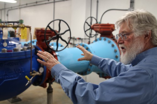 Project engineer Stephen Weatherman explains how all of Sitka’s water is run through the 24-inch pipes in the plant. (Photo by Robert Woolsey/KCAW)