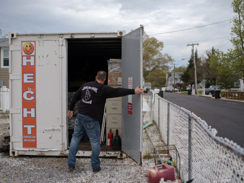Doug Quinn closes his storage container, on the empty lot of his home destroyed by Superstorm Sandy. Bryan Thomas for NPR
