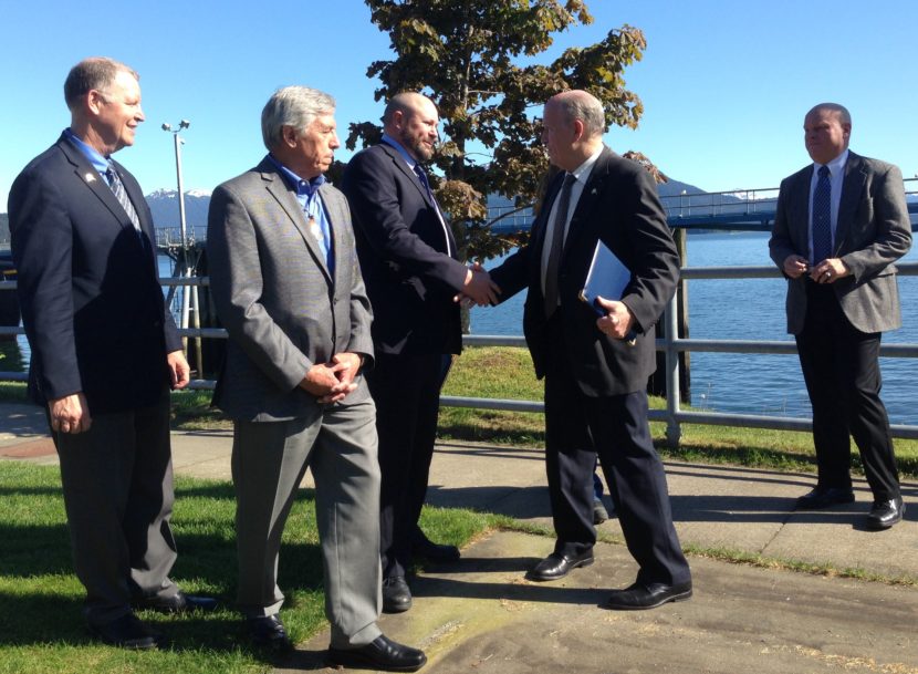 Gov. Bill Walker shakes hands with Southeast Conference President Gary White after signing an agreement to consider changes to ferry system management. Transportation Commissioner Marc Luiken, left, Lt. Gov. Byron Mallott, second from left, and ferry Capt. Mike Neussl, right, look on. (Photo by Ed Schoenfeld/ CoastAlaska News)