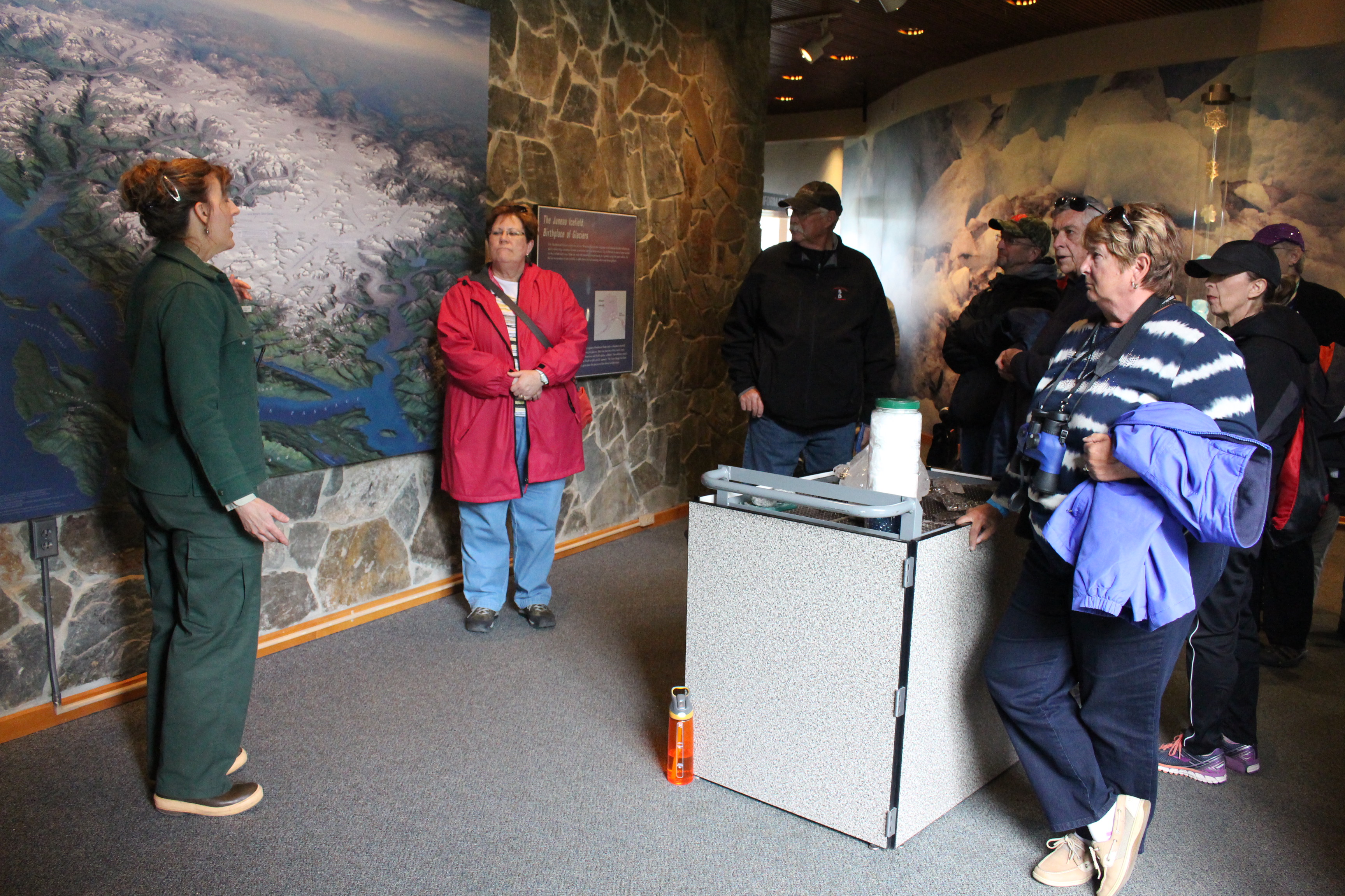 Kat Pratt talks to people inside the Mendenhall Glacier Visitor Center about climate change. (Photo by Elizabeth Jenkins/KTOO)
