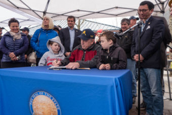 Governor Bill Walker signs a law "establishing August 10 of each year as Alaska Wild Salmon Day" at the 2016 Juneau Maritime Festival (Photo by David Purdy/KTOO)