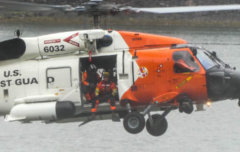 A rescue swimmer prepares to jump from a U.S. Coast Guard helicopter during a search and rescue demo at the 2016 Juneau Maritime Festival (Photo by David Purdy/KTOO)