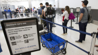 Faced with the prospect of long wait times at airports this summer, Homeland Security is boosting its checkpoint staffing. In this photo from December, passengers line up to go through security at the Fort Lauderdale-Hollywood International Airport. Wilfredo Lee/AP