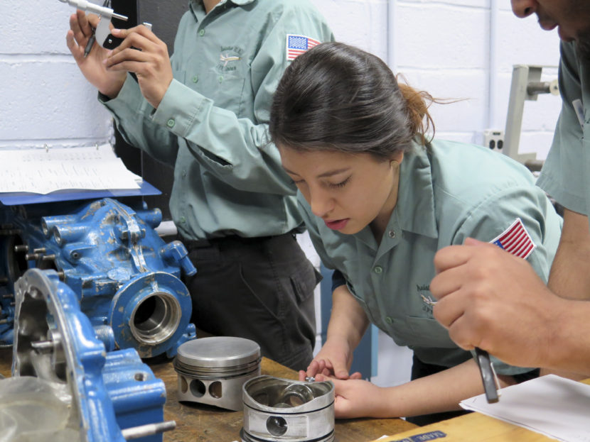Joseline Lazo works on fixing a four-cylinder aircraft engine during class at JFK Airport. Gabrielle Emanuel/NPR