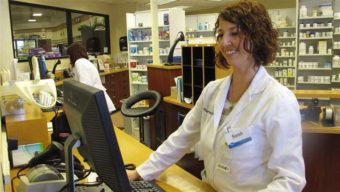 Pharmacist Sarah Burke checks a prescription drug database in Columbus, Ohio, to see whether the patient may be taking any controlled substances. Ohio is one of 16 states that have recently required physicians and other prescribers to run the same type of query before prescribing opioid pain medications. AP