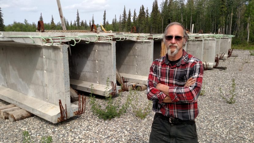 Nenana Mayor Jason Mayrand says the city has bought all the materials needed to build the Nenana River bridge, such as these enormous cast-concrete girders, and stockpiled them near the construction site. (Photo by Tim Ellis/KUAC)