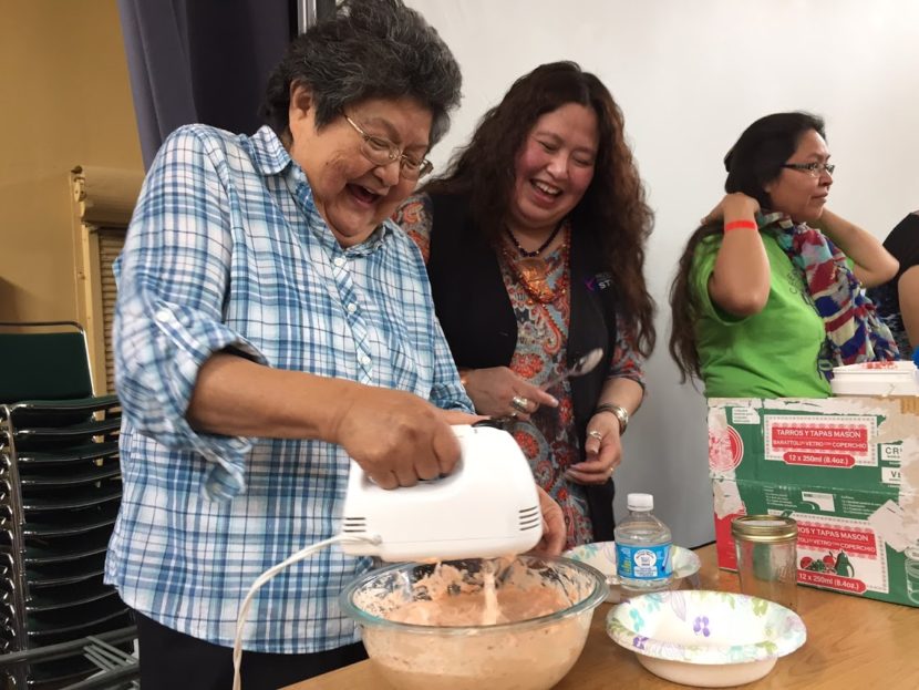 Doris McLean of Whitehorse whips up a jar of soapberries, which took first prize at Sealaska Heritage's contest. Next to her is Leonilei Abbott, daughter of Helen Watkins, who was widely known for teaching about native foods. (Photo by Emily Kwong/KCAW)