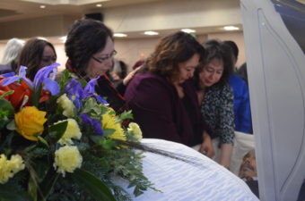 Victoria Canul Dunne (left) and Janine Canul (center) mourn the loss of their brother Mark Canul at his Jan. 26 memorial. (Photo by Jennifer Canfield/KTOO)