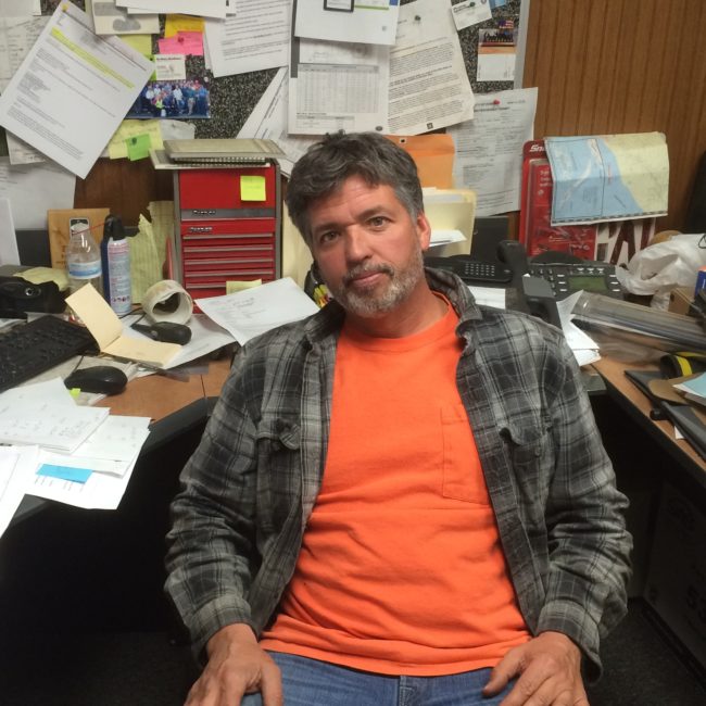 Lloyd Moore sitting inside his office at Moore and Moore Services in Homer. (Photo by Quinton Chandler/KTOO)