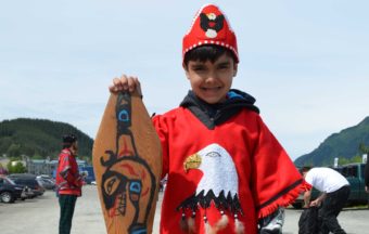 This is Roary Earl Bennett's first joining the One People Canoe Society. He hand-carved his paddle and painted on it a killer whale, representing his grandfather's house. Photo by Emily Kwong/KCAW)