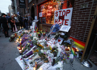 People gather to look at a makeshift memorial for victims of the Orlando nightclub shootings in front of the historic Stonewall Inn, a gay bar in the West Village, on June 13, in New York. Kathy Willens/AP