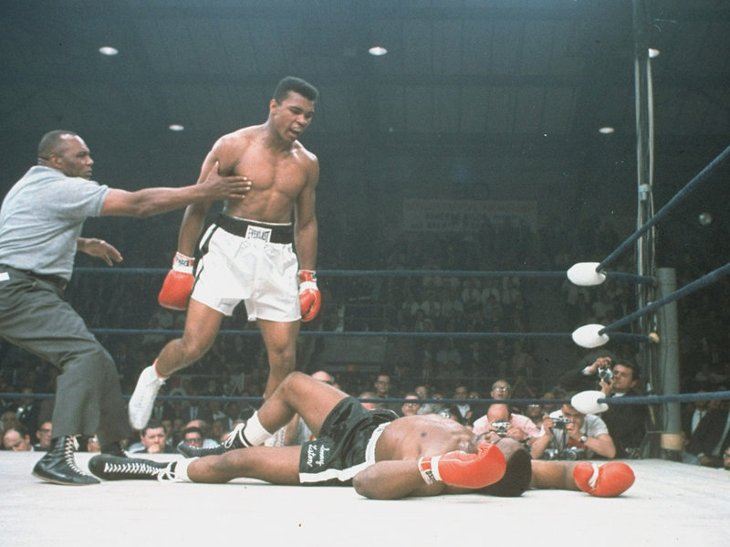 Muhammad Ali is held back by referee Joe Walcott after knocking out Sonny Liston in the first round of their championship bout in Lewiston, Maine, on May 25, 1965.