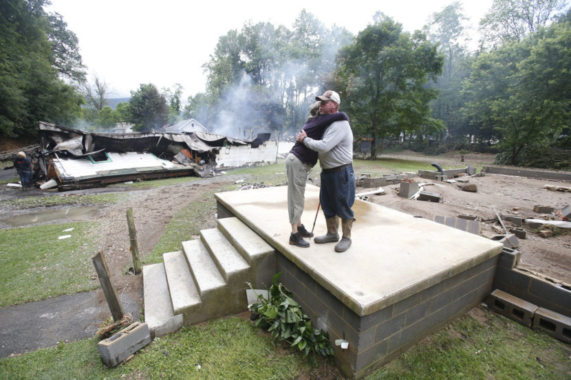 Jimmy Scott gets a hug from Anna May Watson (left) as they clean up from severe flooding in White Sulphur Springs, W. Va., on Friday. Steve Helber/AP