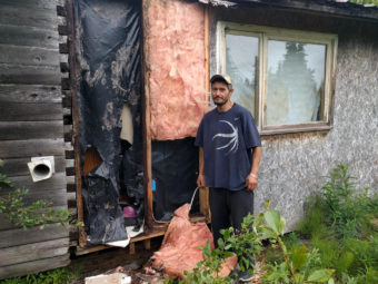 Aaron Hiratsuka stands by the damage caused by a brown bear attempting to get into his home Thursday, June 23. (Photo by Spencer Tordoff/KDLG)