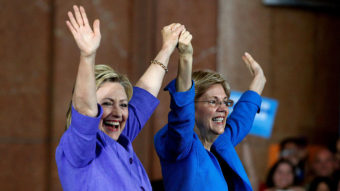 Democratic presidential candidate Hillary Clinton (left) and Sen. Elizabeth Warren wave to the crowd before a campaign rally at the Cincinnati Museum Center at Union Terminal on Monday. John Sommers II/Getty Images