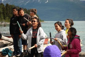 Michelle Ravenmoon (right), Nondalton elder Pauline Hobson (left) and kids sing a Dena’ina song at the end-of-camp potluck (Photo by Hannah Colton, KDLG – Dillingham)
