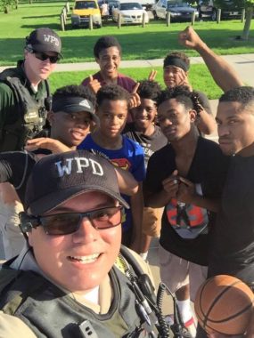 Officers pose with young men on a basketball court during a community cookout in Wichita, Kansas. (Photo courtesy Wichita Police)