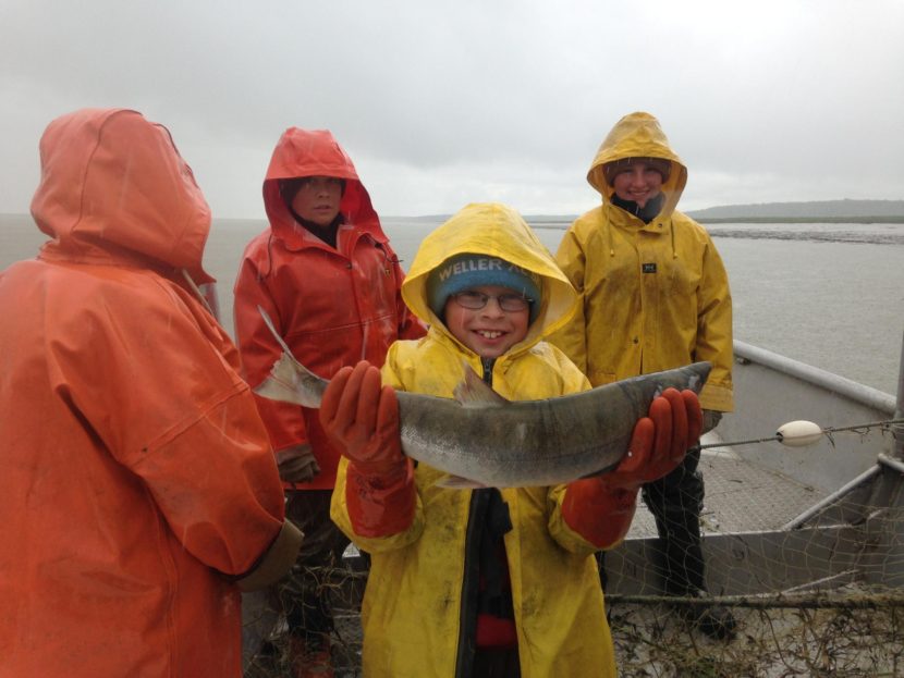 James Shawcroft holds up what might have been the 2 billionth commercially caught salmon in Bristol Bay’s history at Coffee Point, July 6, 2016. (Photo by KDLG)