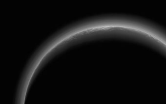 NASA’s New Horizons spacecraft took this stunning image of Pluto only a few minutes after closest approach on July 14, 2015. The image was obtained at a high phase angle –that is, with the sun on the other side of Pluto, as viewed by New Horizons. Seen here, sunlight filters through and illuminates Pluto’s complex atmospheric haze layers. The southern portions of the nitrogen ice plains informally named Sputnik Planum, as well as mountains of the informally named Norgay Montes, can also be seen across Pluto’s crescent at the top of the image. Top right detail of Pluto’s crescent shows an intriguing bright wisp (near the center) measuring tens of miles across that may be a discreet, low-lying cloud in Pluto’s atmosphere.